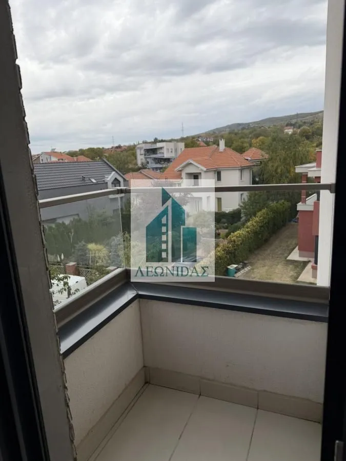 Pogled sa balkona na okolne kuće i pejzaž.