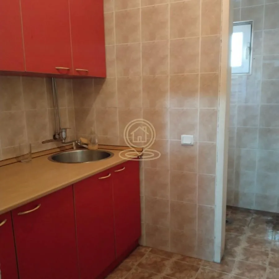 Small kitchen with red cabinets and a sink.