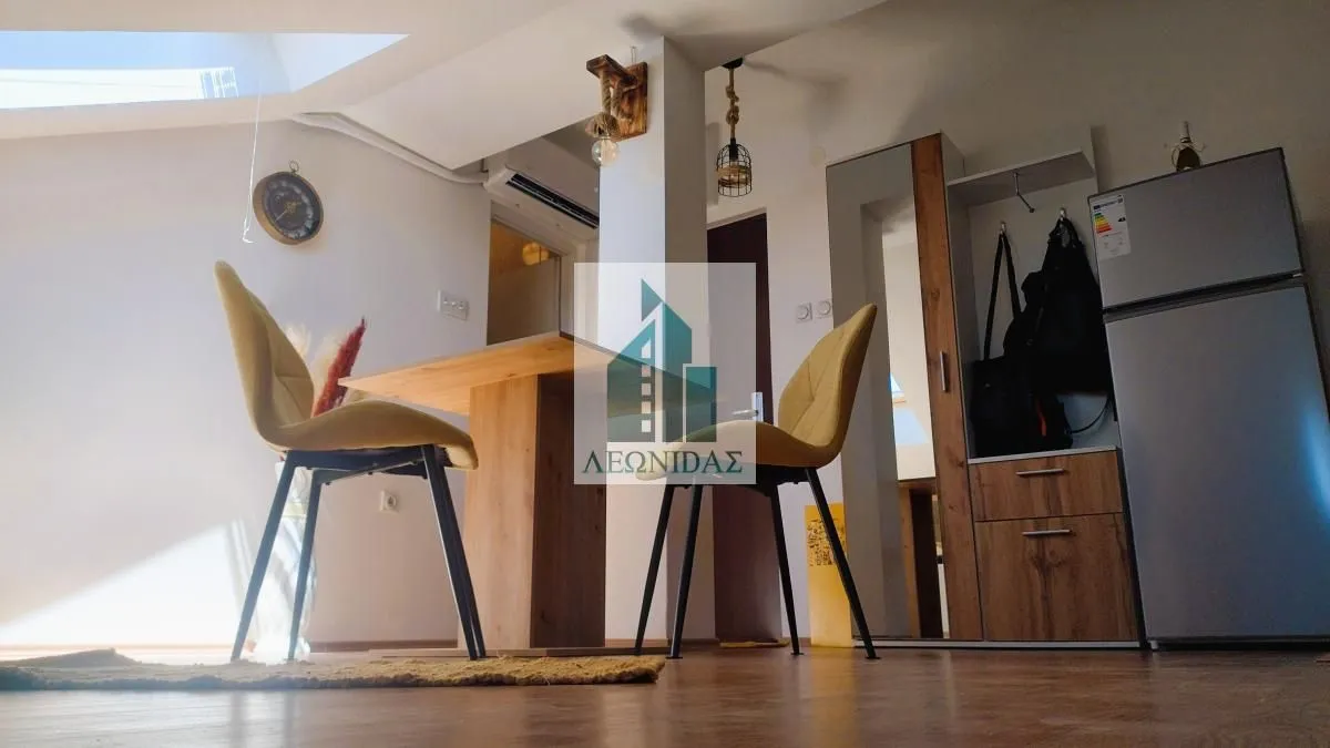 Small living room with a dining table and yellow chairs.