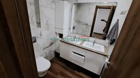 Savremeno opremljeno kupatilo sa umivaonikom, ogledalom i toaletom. - image 14