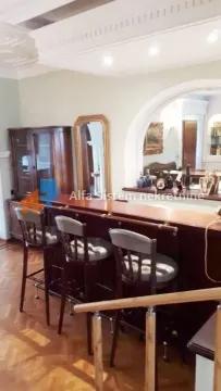 Living room with a bar counter and wooden furniture. - image 11