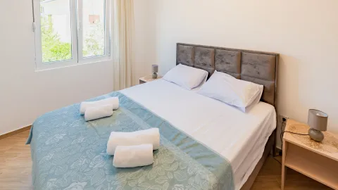 Svijetla spavaća soba sa bračnim krevetom, bijelom posteljinom i prozorom. - image 5