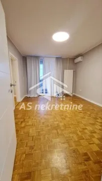 Prazna soba sa parketom i prozorom prekrivenim zavesama. - image 2