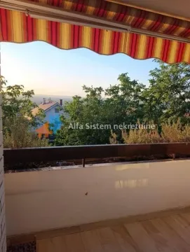 Natkriveni balkon sa pogledom na zelenilo i okolne kuće. - image 20