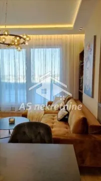 Living room with a comfortable sectional sofa, large windows, and modern lighting. - image 3