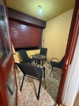 Small enclosed balcony with seating set and a small table. - image 5