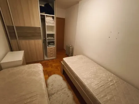 Bedroom with two single beds and a built-in wardrobe. - image 10