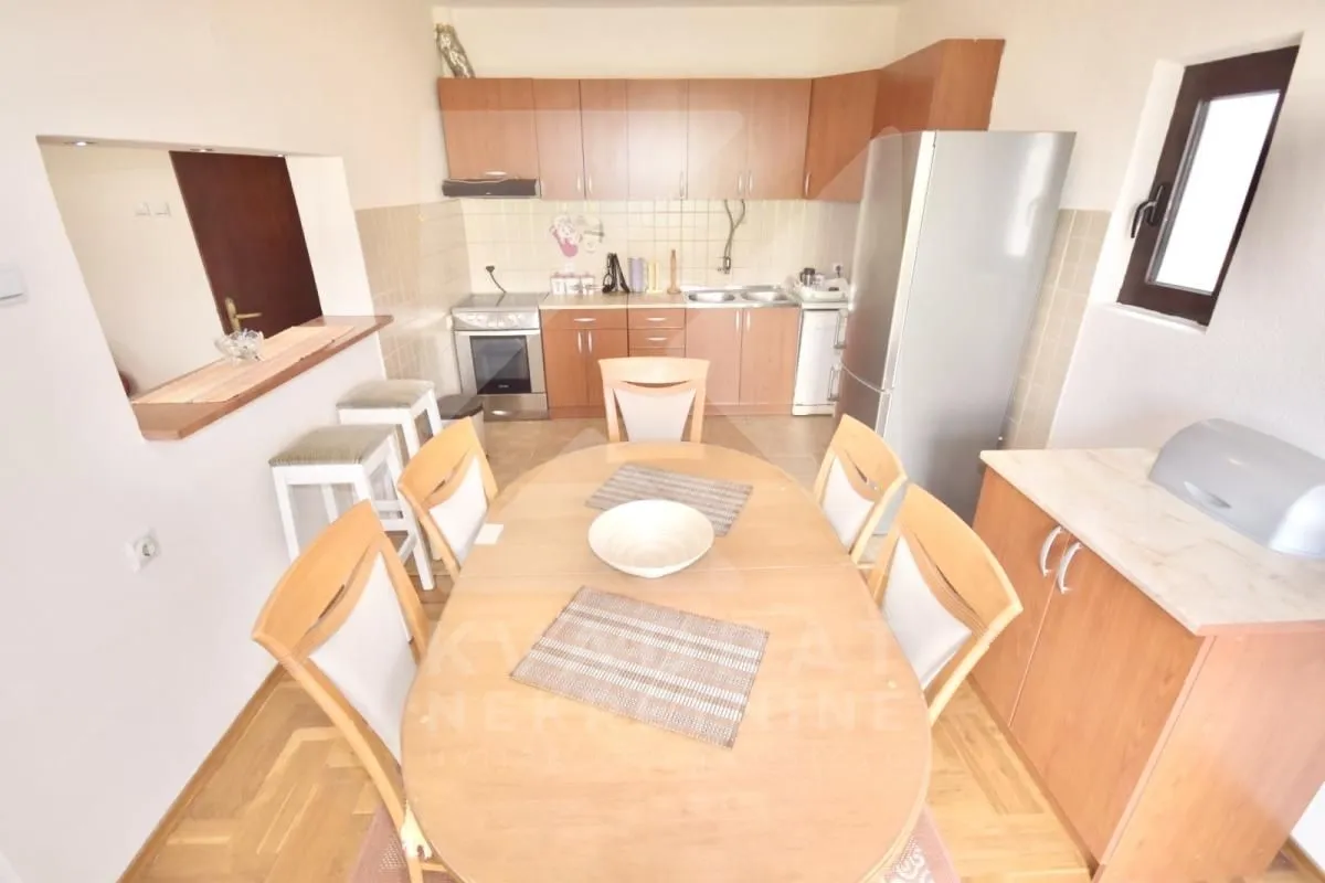 Kitchen with dining area and wooden cabinets.
