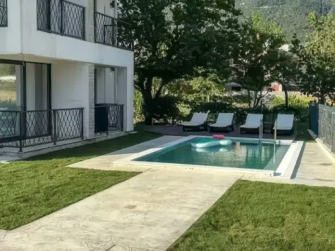 Pogled na dvorište zgrade sa bazenom i ležaljkama. - image 3