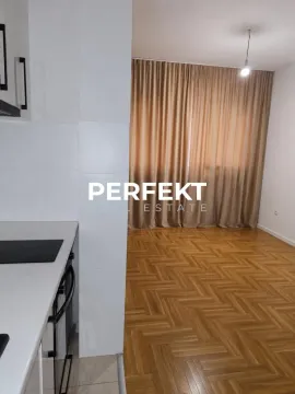 Manja kuhinja sa belim elementima i pogledom na prostoriju sa parketom. - image 10