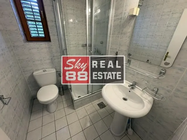 Bathroom equipped with a shower cabin, washbasin, and toilet.