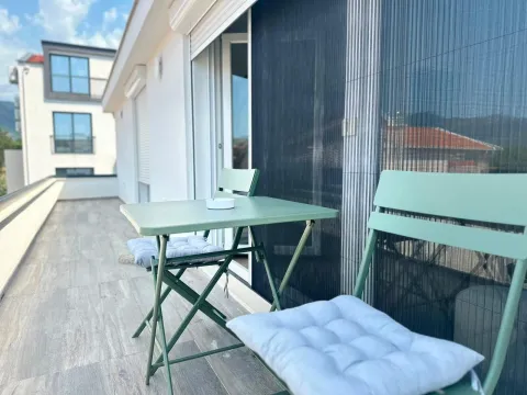 Spacious terrace with a table and chairs for seating. - image 17