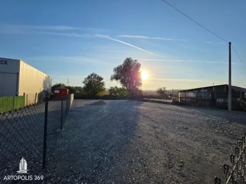 Pogled na ograđeni plac sa šljunkovitom podlogom i okolnim rastinjem. - image 6