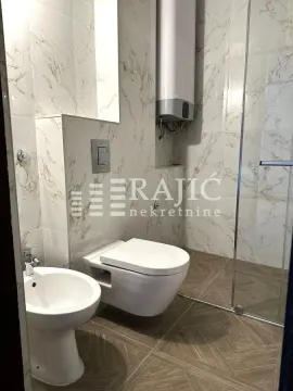 Modern bathroom with white sanitary ware and marble tiles. - image 12