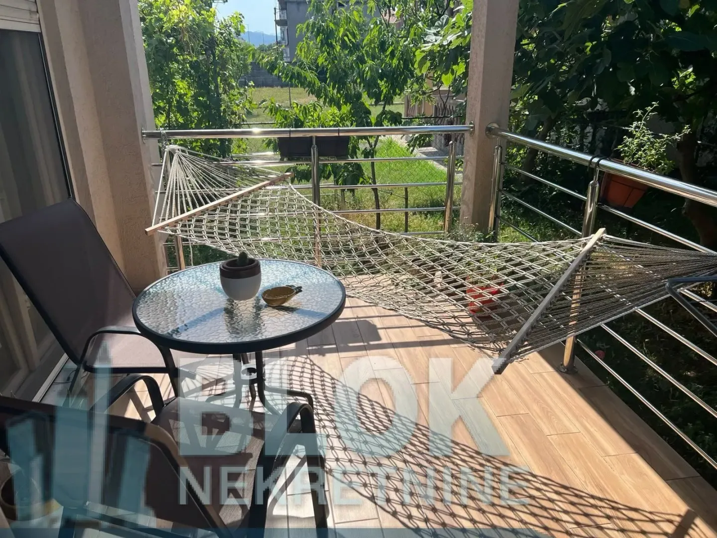 Furnished terrace with a table, chairs, and a hammock.