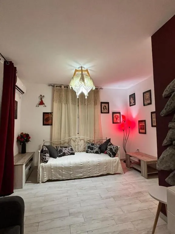 Manja spavaća soba sa krevetom i dekorativnim osvjetljenjem.