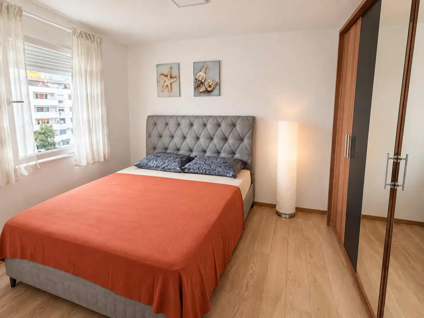 Furnished bedroom with a double bed, wardrobe, and a window.