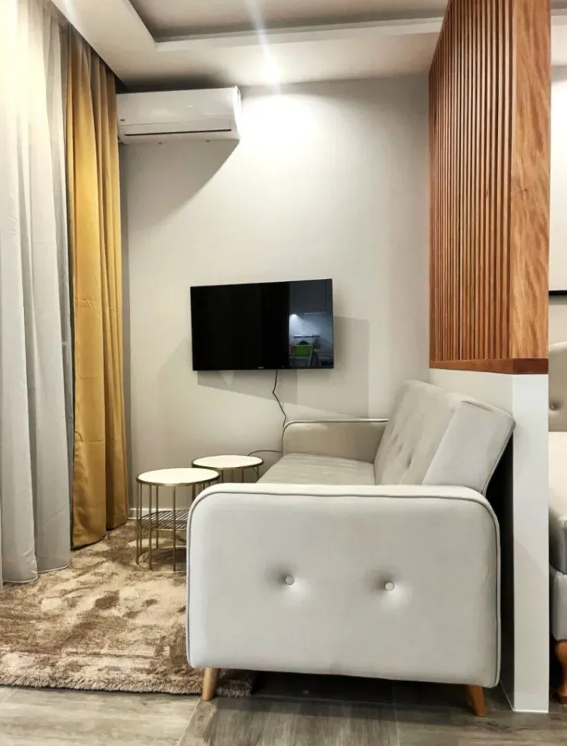 Modern and tidy living room with a sofa and wall-mounted TV.