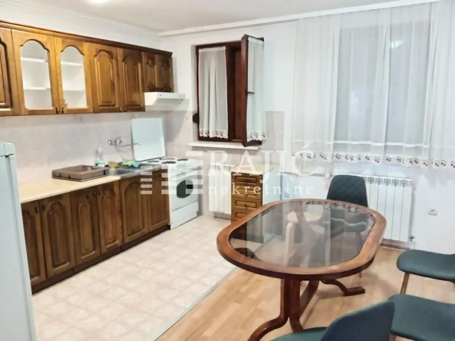 Kitchen with wooden cabinetry and a dining table.