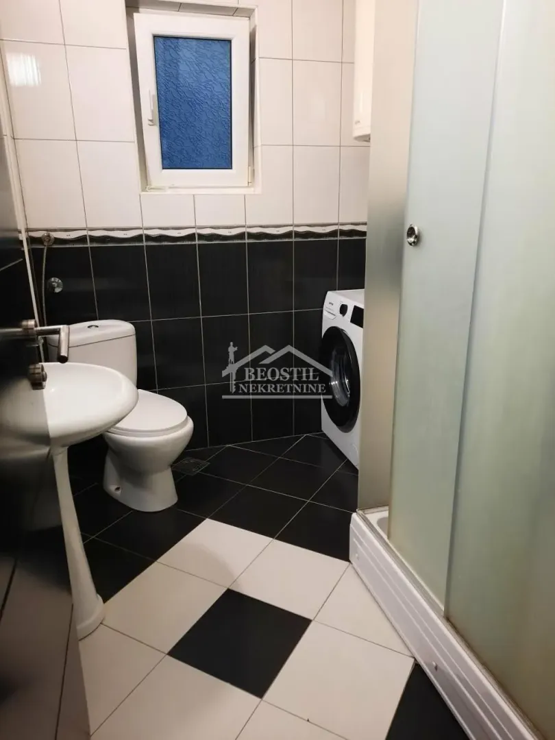 Bathroom equipped with sanitary ware, a shower cabin, and a washing machine.
