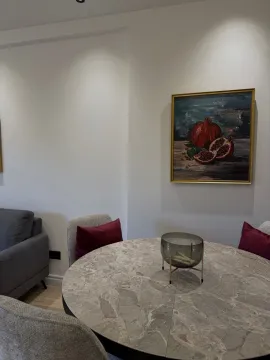 Dining table with chairs and an artwork on the wall. - image 15
