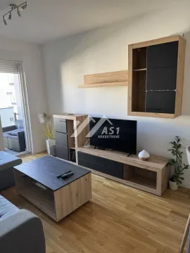 Dnevna soba sa garniturom, TV komodom i izlazom na terasu. - image 2