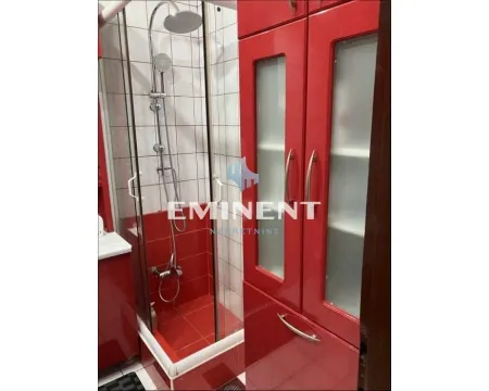Bathroom with a shower cabin and red bathroom furniture. - image 11