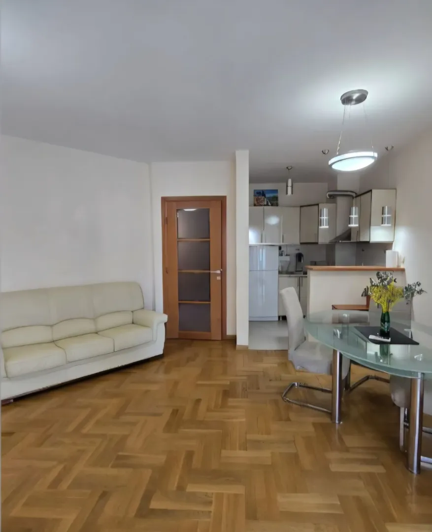 Living room with a sofa and dining area in an open-plan layout with the kitchen.