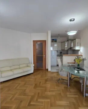 Living room with a sofa and dining area in an open-plan layout with the kitchen. - image 3