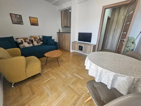Dnevni boravak sa garniturom, trpezarijskim stolom i kuhinjom u pozadini. - image 5
