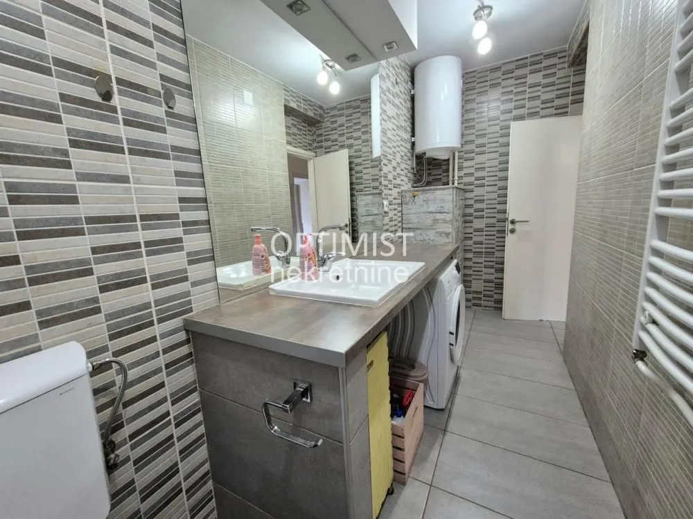 Bathroom with a sink, large mirror, and washing machine.