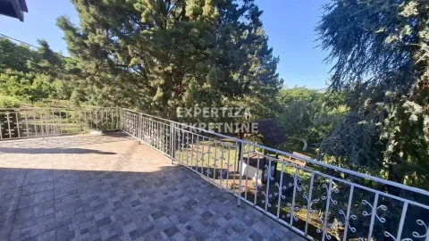 Spacious terrace with a metal railing and a view of the yard and greenery. - image 3