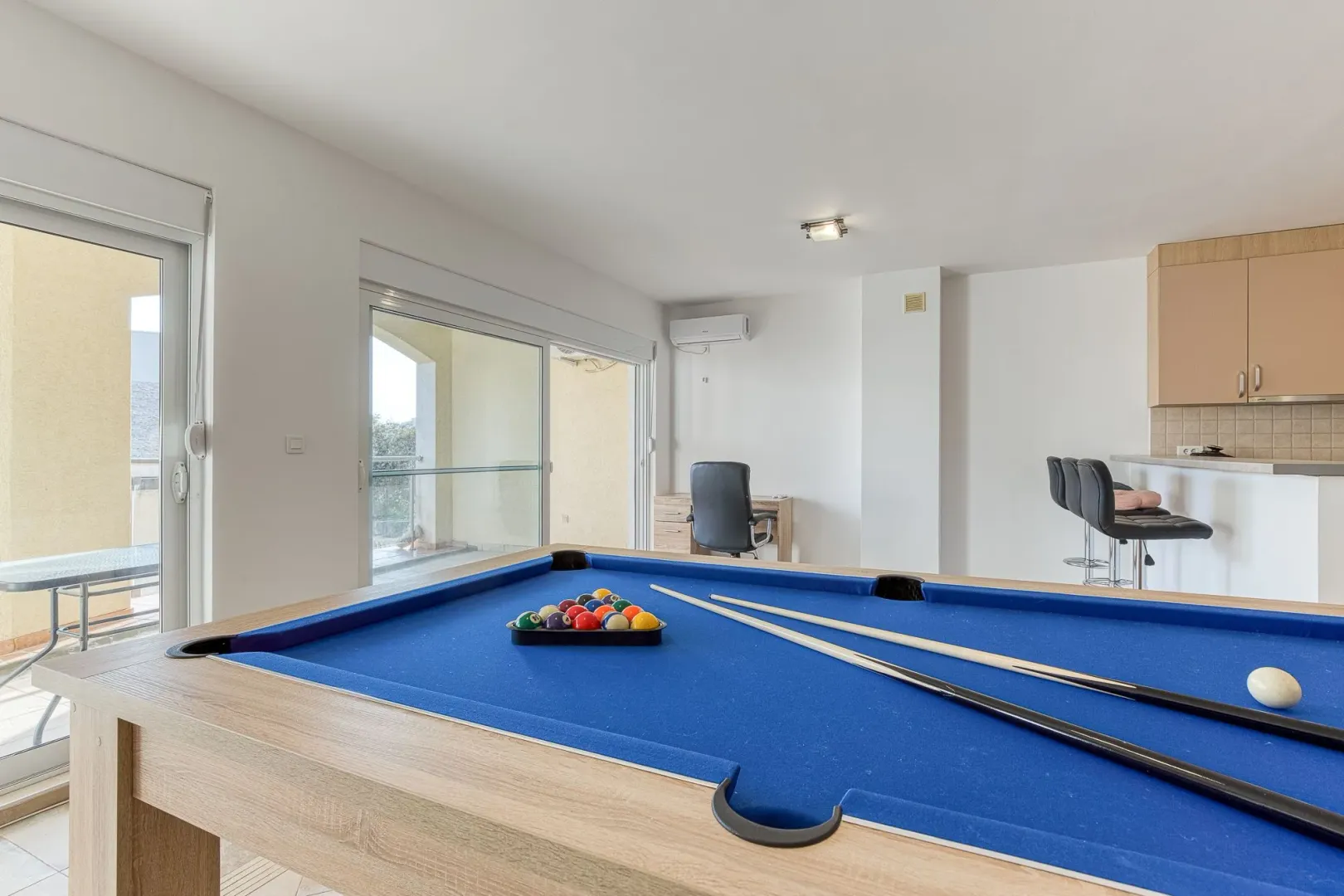Living room with a billiard table and access to the terrace.