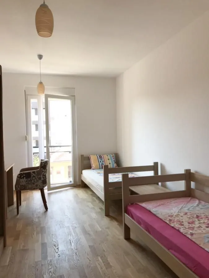 Spavaća soba sa dva kreveta i izlazom na terasu.