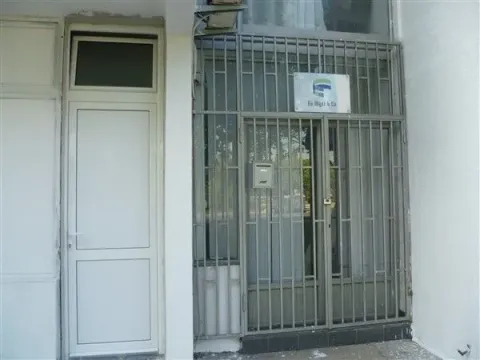 Entrance to a commercial space with metal grates. - image 2