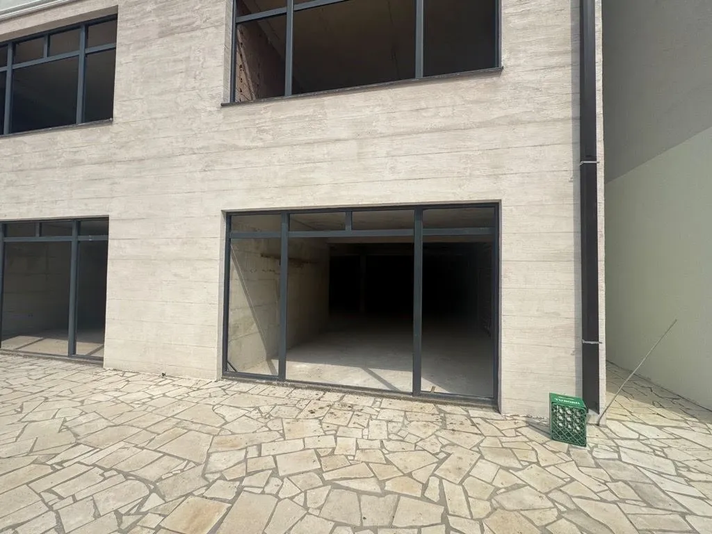 View of the exterior of the building with a paved yard and openings for windows and doors.