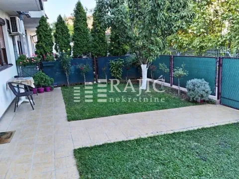 Landscaped courtyard with lawn, pathway, and greenery in front of the building. - image 2