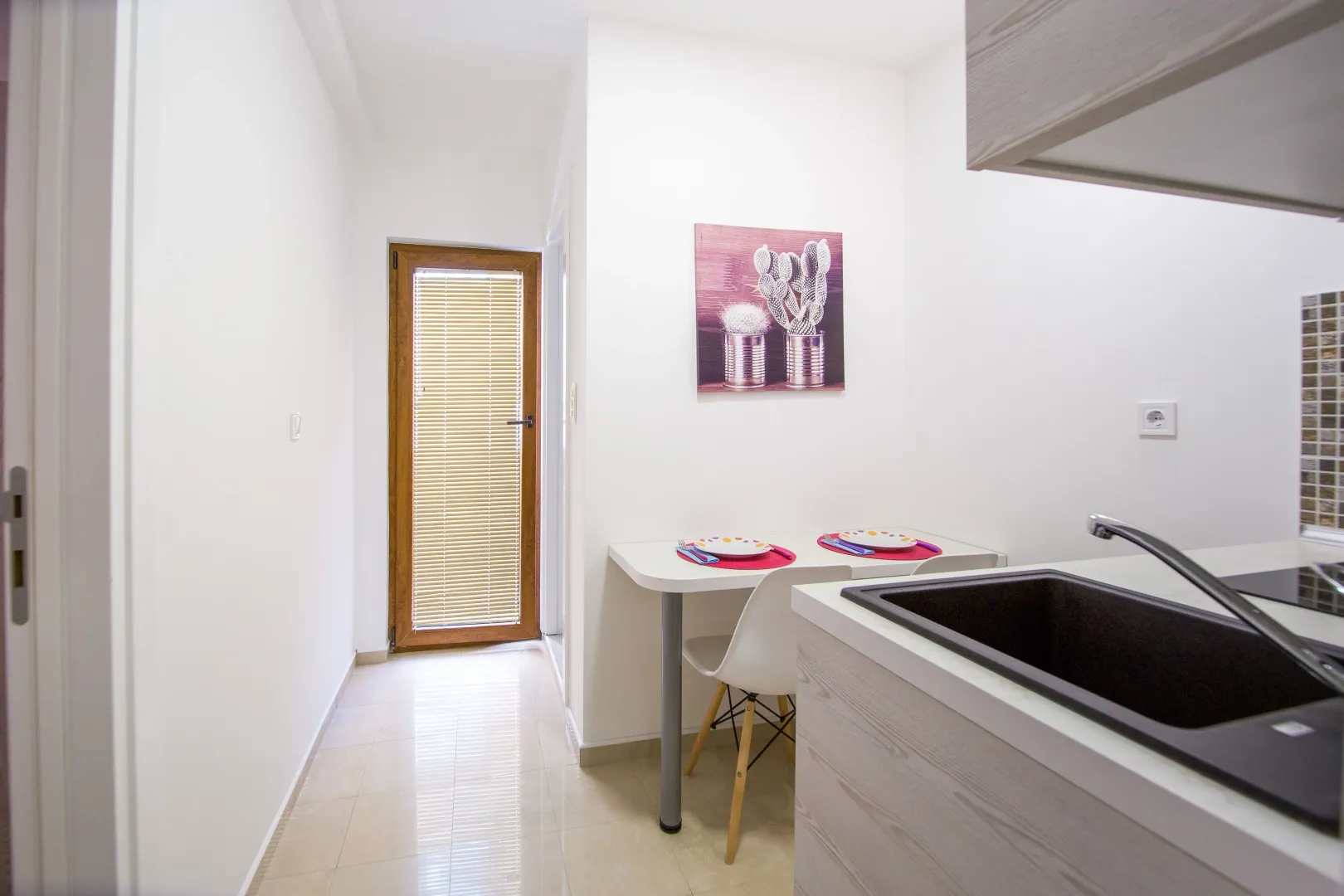 Small bright kitchen with a dining table and chairs.