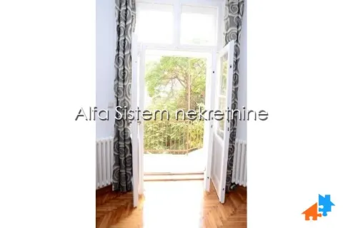 View through open balcony doors with curtains towards the greenery outside. - image 5