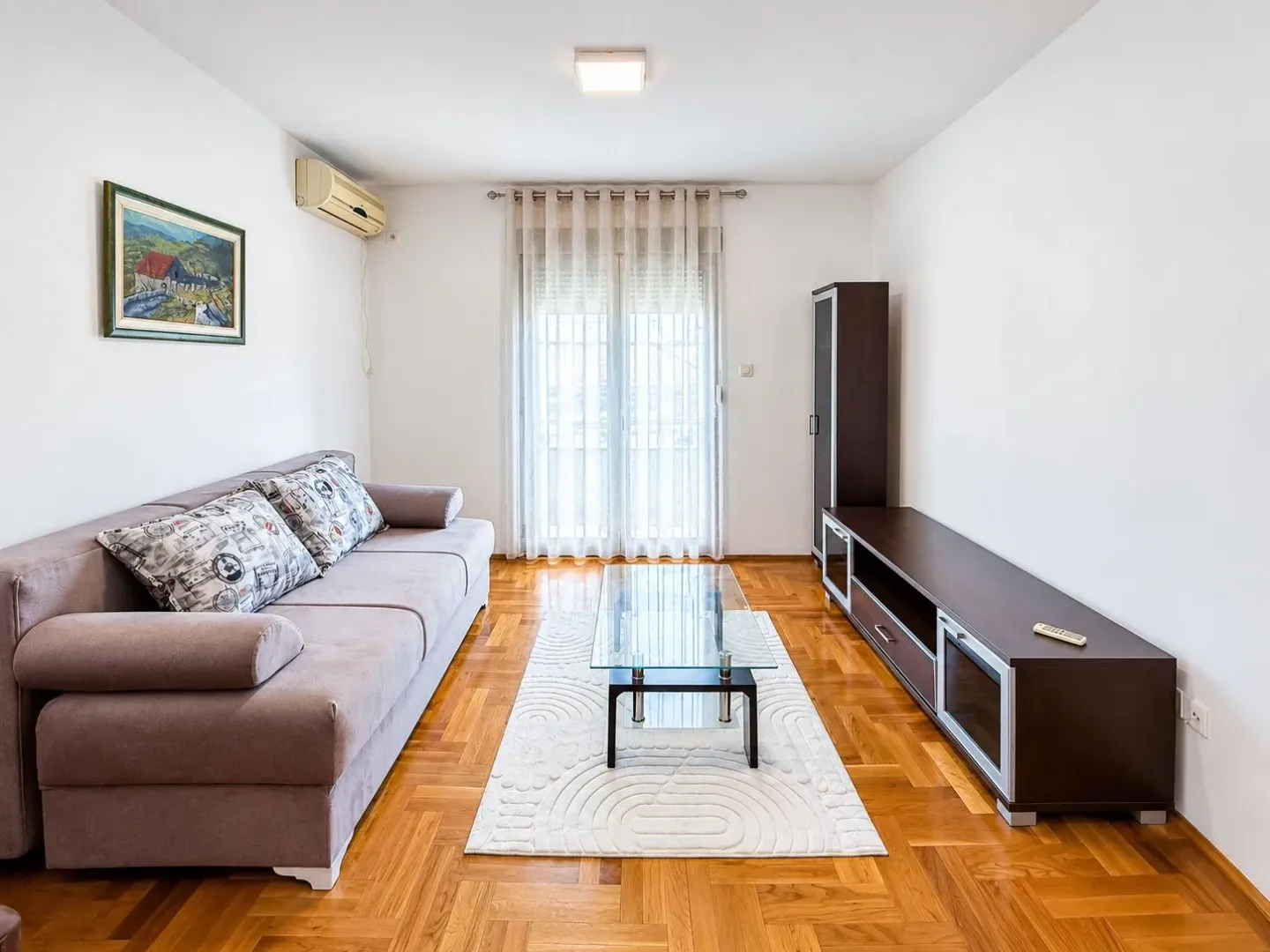 Living room with a sofa, coffee table, and TV cabinet.