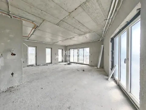 Nedovršena prostorija u sivoj fazi sa velikim prozorima i instalacijama. - image 3
