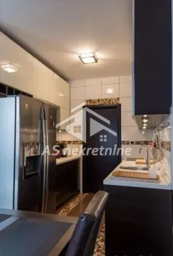 View of a modern equipped kitchen with a refrigerator and countertops. - image 6