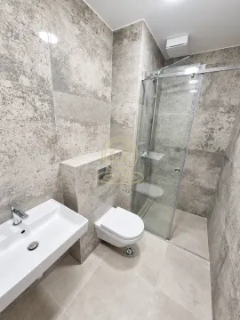 Moderno kupatilo obloženo keramičkim pločicama sa tuš kabinom i umivaonikom. - image 9