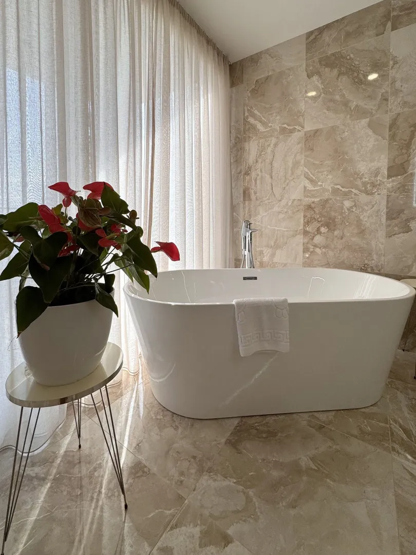 Bathroom with a freestanding bathtub and marble tiles.