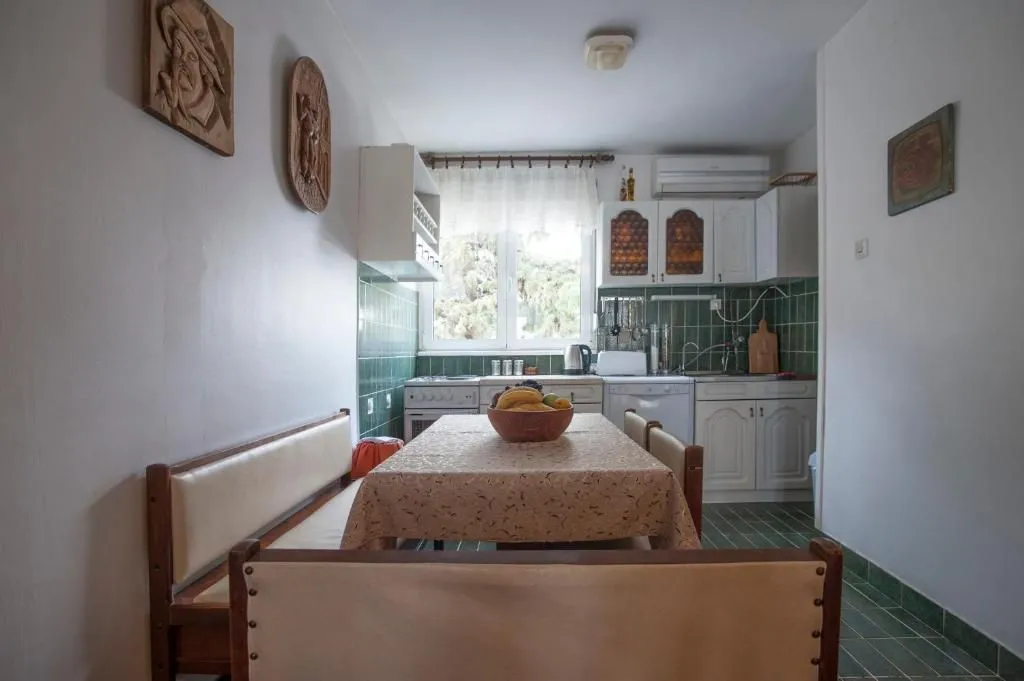 Smaller kitchen with a dining table and wooden benches.