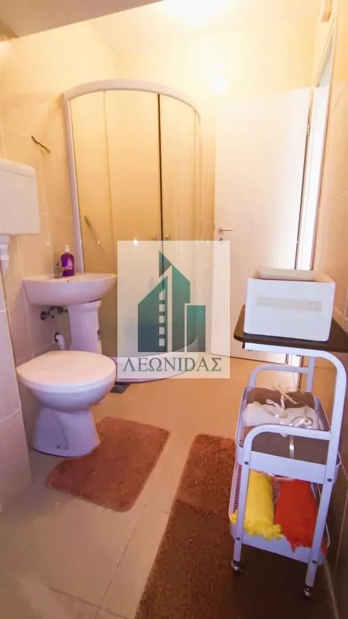 Bathroom equipped with a shower cabin, washbasin, and toilet.