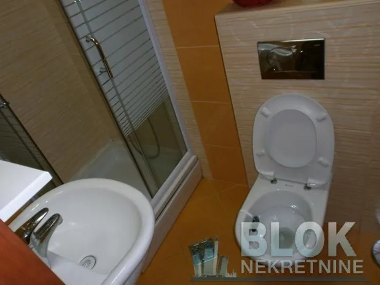 Bathroom equipped with a toilet, washbasin, and shower cabin.