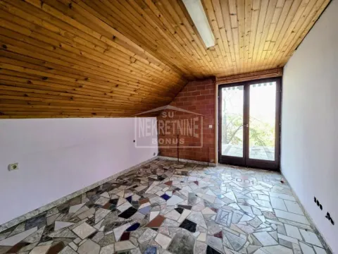 Prazna potkrovna prostorija sa drvenom lamperijom i izlazom na terasu. - image 4
