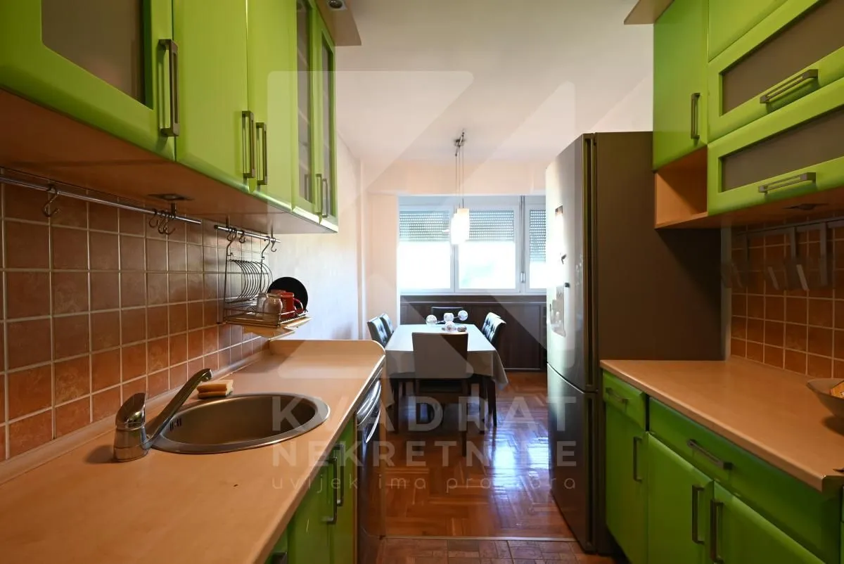 Kitchen with green cabinets and a view of the dining area.