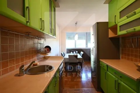 Kitchen with green cabinets and a view of the dining area. - image 8